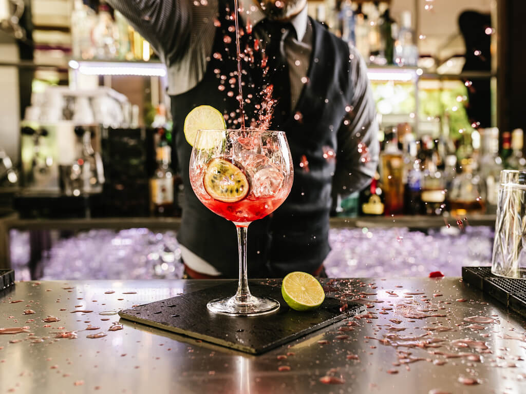 bartender pouring drink into glass